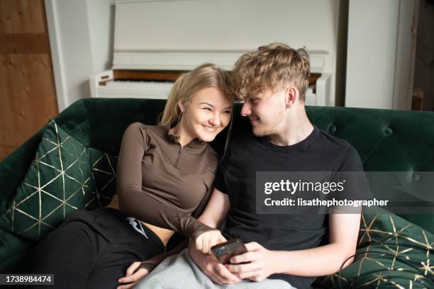 teen couple using mobile technology - young love stock pictures, royalty-free photos & images