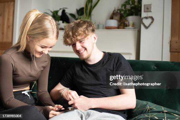 teen couple using mobile technology - teen dating stock pictures, royalty-free photos & images