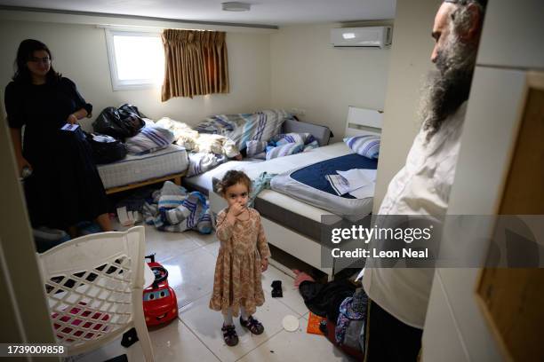 Young girl is watched by her parents in the temporary room they share at the Shemesh Hostel, on October 16, 2023 in Beit Shemesh, Israel. The family...