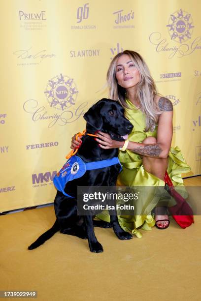 Sabrina Setlur and a Vita assistance dog attends the VITA Charity Gala on October 14, 2023 in Wiesbaden, Germany.