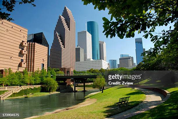 moderne wolkenkratzer in der innenstadt von houston, texas, mit waterway und park - houston texas stock-fotos und bilder