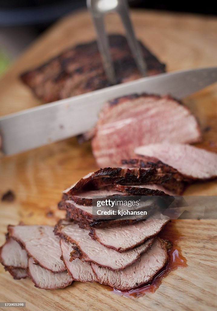 Freshly sliced BBQ beef on wooden cutting board