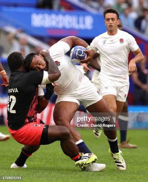 Manu Tuilagi of England is tackled by Joshua Tuisova during the Rugby World Cup France 2023 Quarter Final match between England and Fiji at Stade...