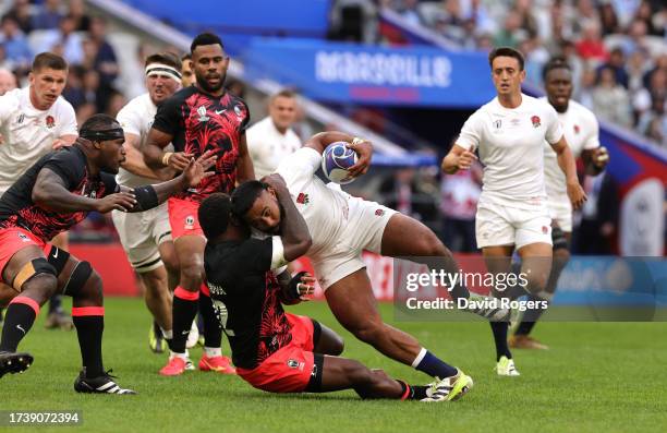 Manu Tuilagi of England is tackled by Joshua Tuisova during the Rugby World Cup France 2023 Quarter Final match between England and Fiji at Stade...