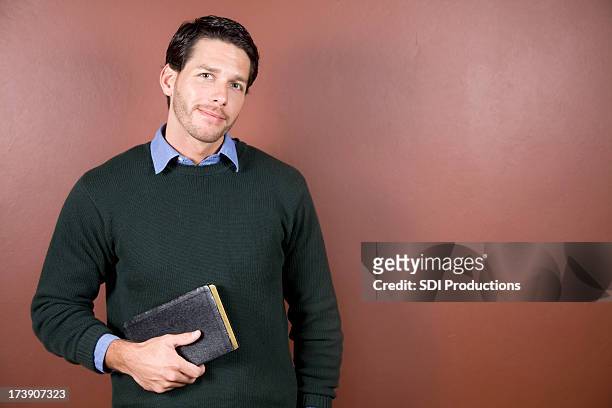 young man holding bibel mit textfreiraum - preacher stock-fotos und bilder