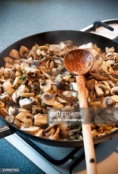 champignon frying pan gas stove kochlöffel - angebraten stock-fotos und bilder