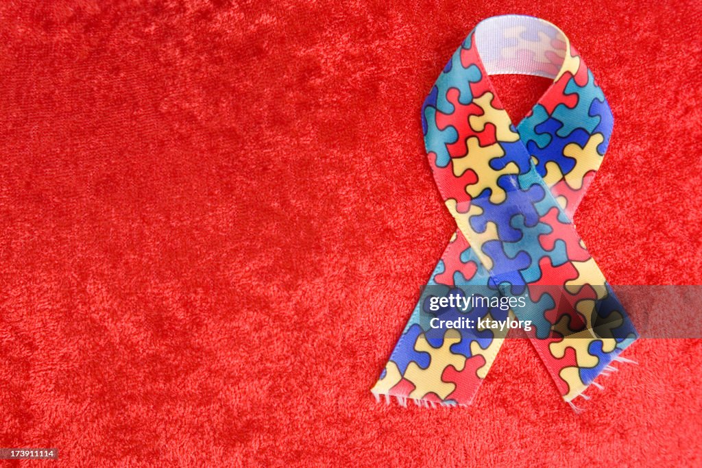 Autism ribbon on textured red background