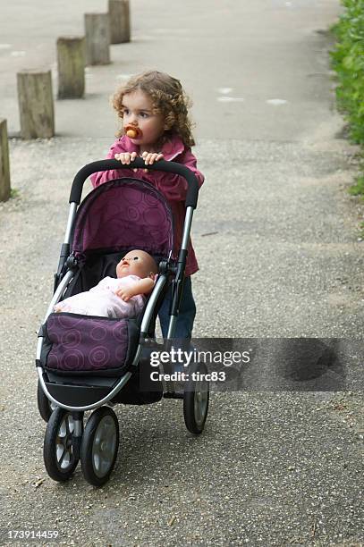 two year old girl with dolls pram - stroller stock pictures, royalty-free photos & images