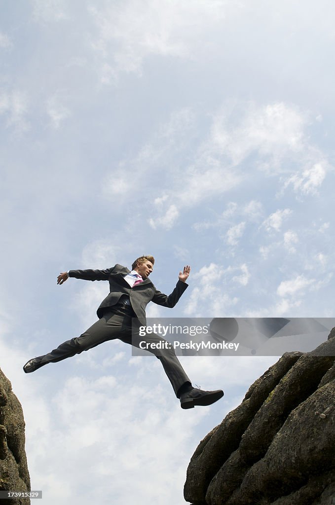 Courageous Businessman Jumping Over Valley