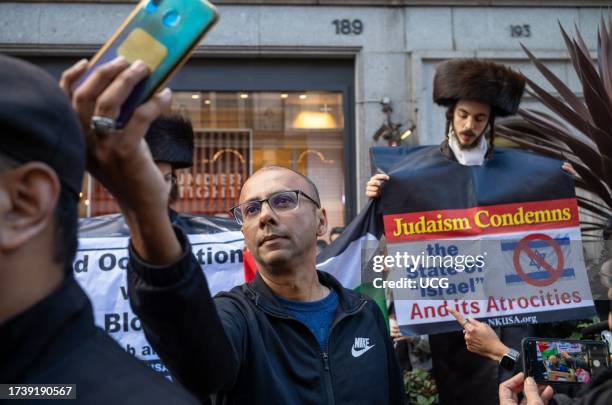 London, UK, A Muslim man stops to take a selfie with a man from the fringe Haredi Jewish group Neturei Karta, or Guardians of the City, protest n...