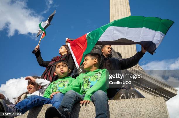 London, UK, Muslim parents wave flags with their three young children at the base of Nelson's column in support of Palestine and against Israeli...