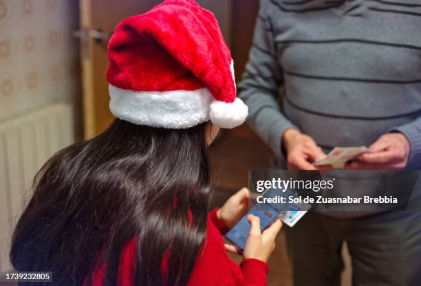 young girl in santa hat checking lottery on smartphone - el gordo christmas lottery foto e immagini stock