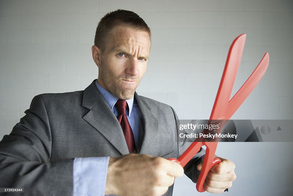 Businessman Gets Serious about Cutting Costs with Red Scissors