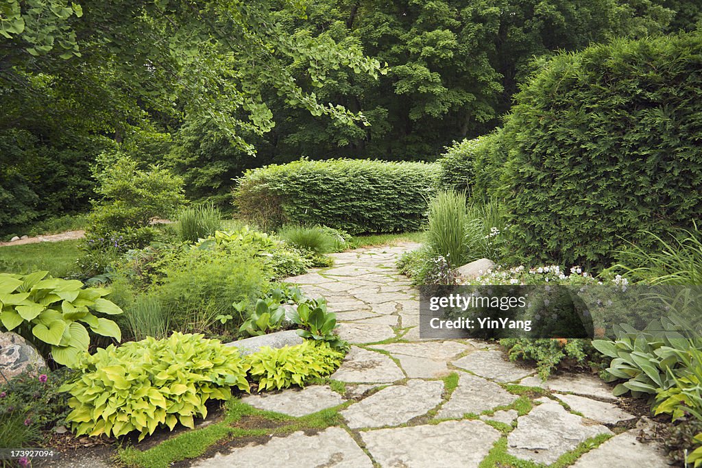 Patio aménagé avec raffinement des jardins paysagers, des fleurs et un chemin de pierres