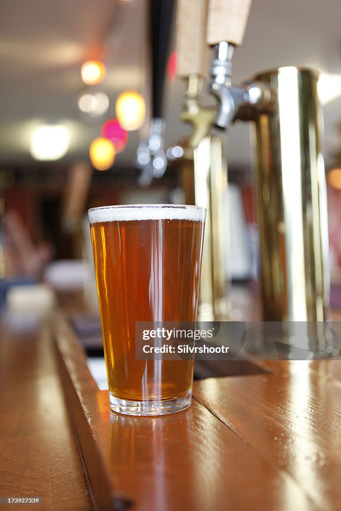 Pint of beer sitting on a bar