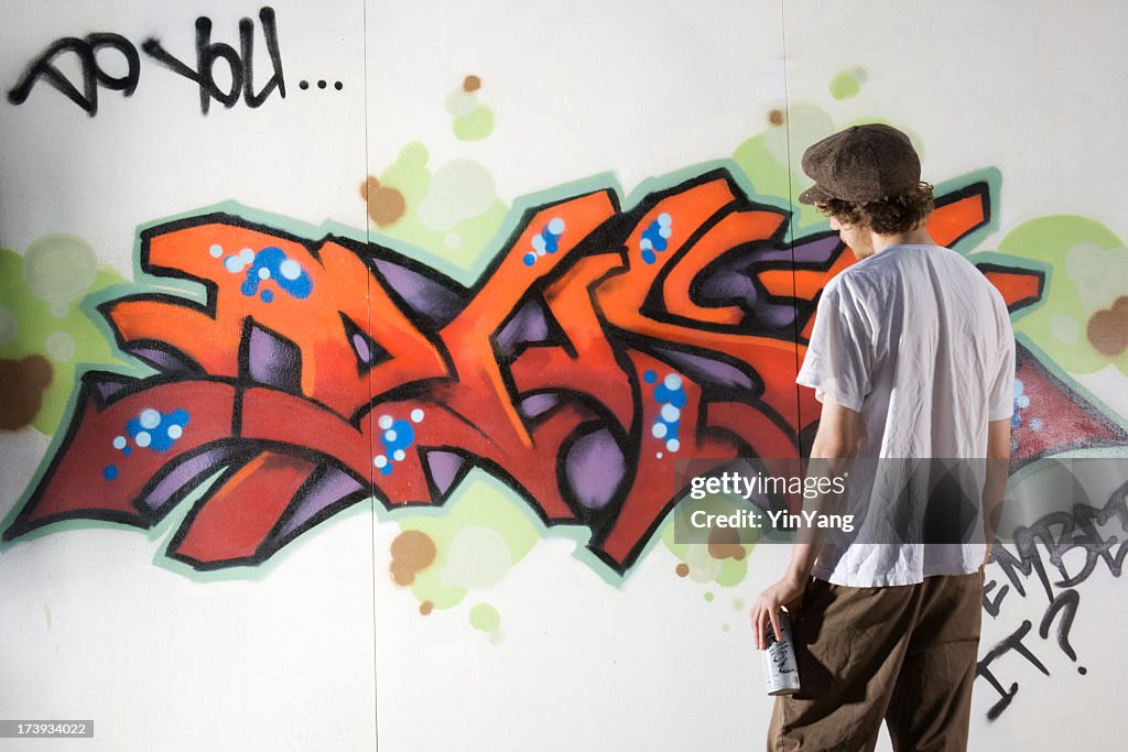 Adolescente artista de Graffiti y pintura con pulverizador de Wall Street Art, Rebelling, Vandalizing