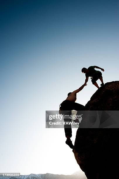 helping hand - berg klimmen team stockfoto's en -beelden