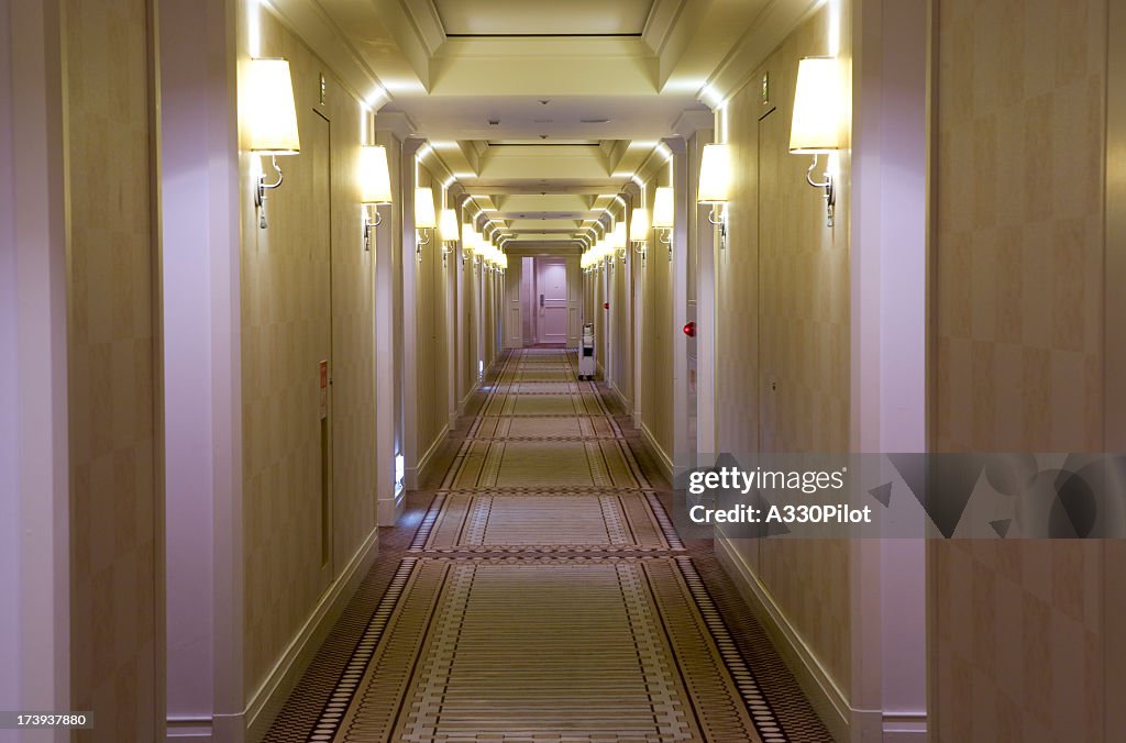 Hotel style, cream colored hallway with lamps