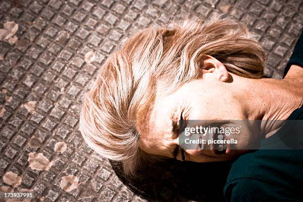 a woman lying in pain on a tile floor - epilepsy stock pictures, royalty-free photos & images