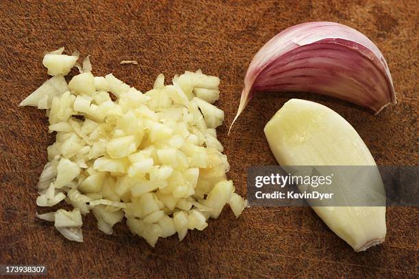 finely chopped garlic on a wooden cutting board - pared stockfoto's en -beelden