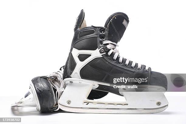 a pair of black and silver ice skates on a white background - hockey player black background stock pictures, royalty-free photos & images