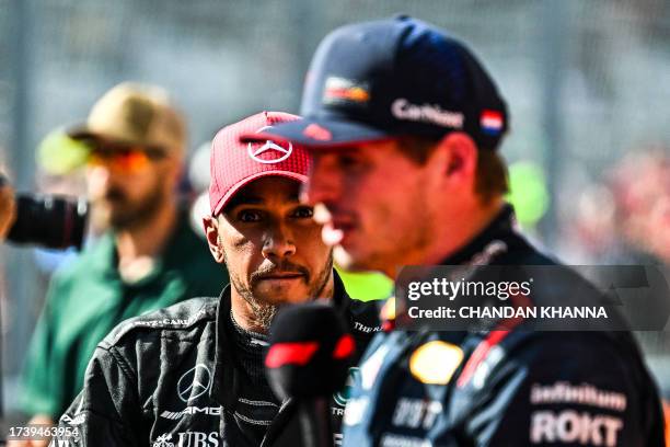 Mercedes' British driver Lewis Hamilton warches as Red Bull Racing's Dutch driver Max Verstappen is interviewed after winning the 2023 United States...