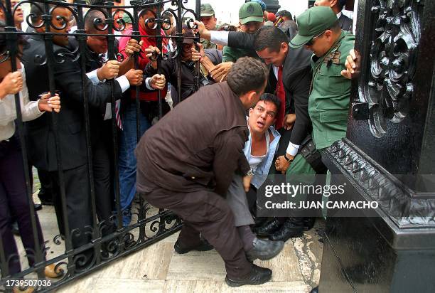 Venezuelan National Assembly security guards drag opposition deputy Wilmer Azuaje out of the building after staging a demonstration against President...