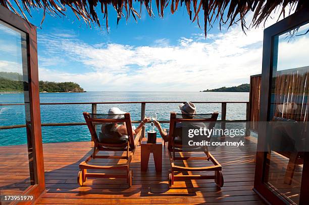 couple relaxing in an over water bungalow - fiji people stock pictures, royalty-free photos & images