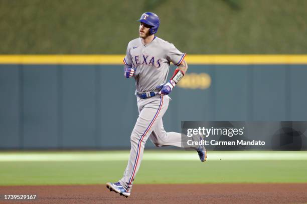 Jonah Heim of the Texas Rangers rounds the bases after hitting a solo home run against Framber Valdez of the Houston Astros during the third inning...