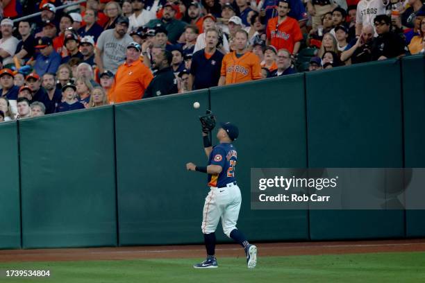 Michael Brantley of the Houston Astros catches a ball hit by Evan Carter of the Texas Rangers during the fourth inning in Game Two of the American...