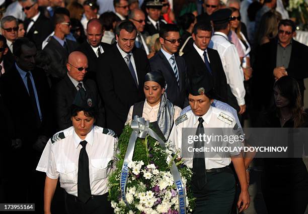 Relatives and officials pay respect on July 18, 2013 at a memorial dedicated to the five Israeli and one Bulgarian victims of a suicide blast which...