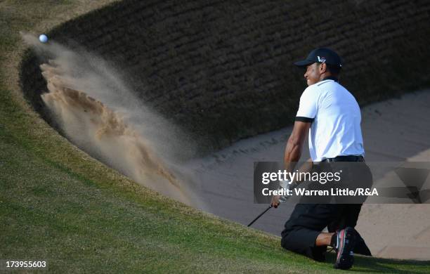 Tiger Woods of the United States hits from a bunker on the 12th hole during the first round of the 142nd Open Championship at Muirfield on July 18,...