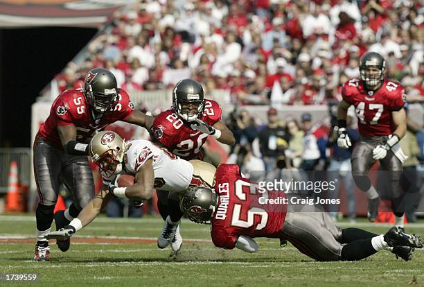 Wide receiver JJ Stokes of the San Francisco 49ers is tackled by Derrick Brooks, Ronde Barber and Shelton Quarles of the Tampa Bay Buccaneers in the...