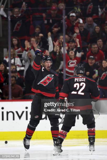 Jordan Staal of the Carolina Hurricanes reacts with teammate Brett Pesce after scoring a goal during the third period of their game against the...