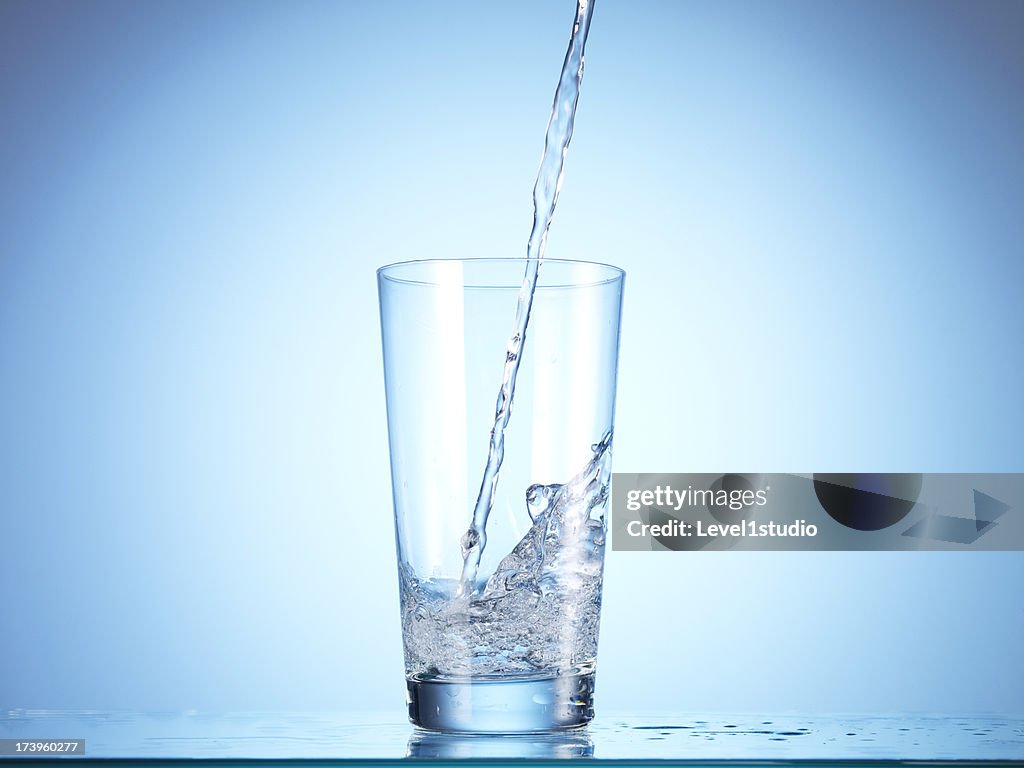 Cold drink water being poured into glass