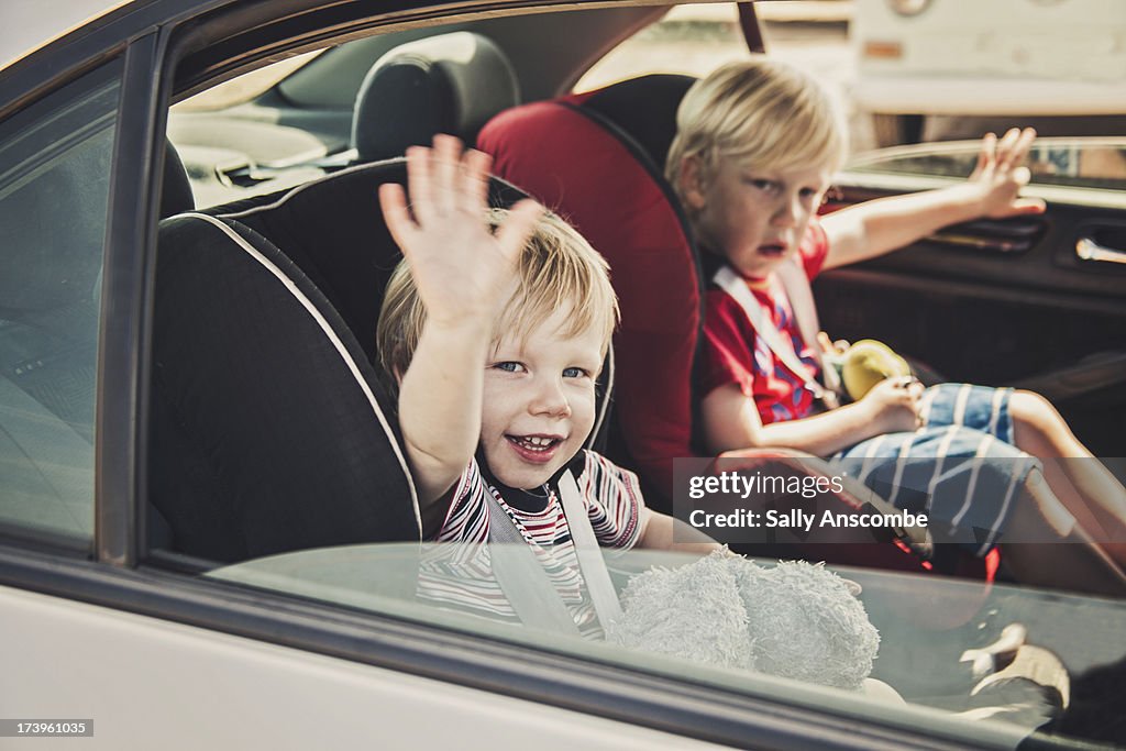 Children waving from in the car