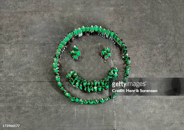 crowd forming a happy smiley - green smiley face stockfoto's en -beelden