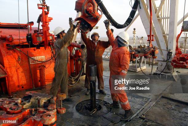 Kuwait Oil Company workers change pipes on a drilling rig January 22, 2003 on the northern border between Iraq and Kuwait in Kuwait. Kuwait produces...