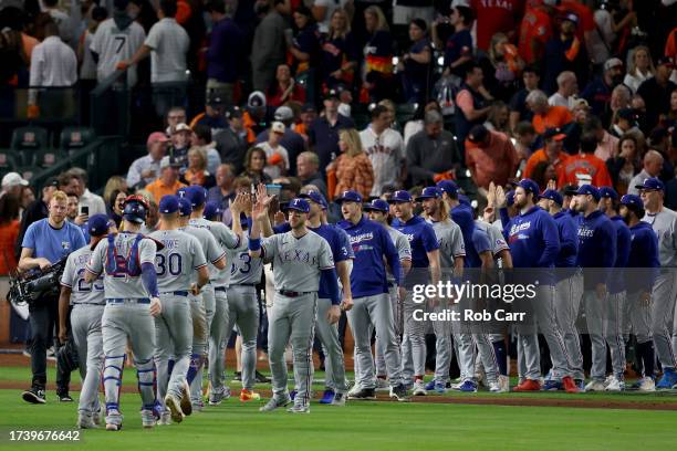 The Texas Rangers celebrate after defeating the Houston Astros in Game Two of the American League Championship Series at Minute Maid Park on October...