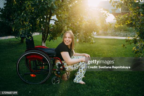 girl with cerebral palsy in a wheelchair enjoys the beauty in the garden near the house - world kindness day stock pictures, royalty-free photos & images