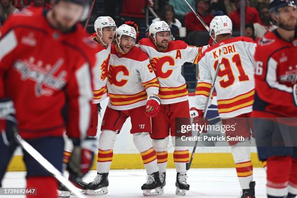 Adam Ruzicka of the Calgary Flames celebrates his goal with teammates against the Washington Capitals during the first period at Capital One Arena on...