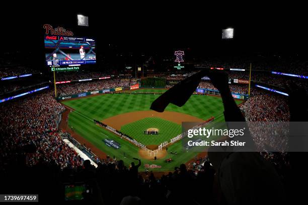Fans cheer during the national anthem prior to the start of Game One of the Championship Series between the Arizona Diamondbacks and the Philadelphia...