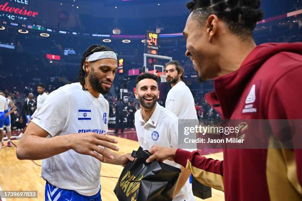 Jason Seggers of Maccabi Ra'anana exchanges a gift with Zhaire Smith of the Cleveland Cavaliers prior to a preseason exhibition game at Rocket...