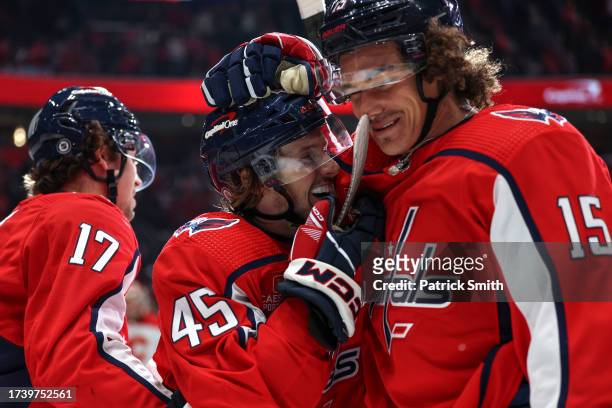 Matthew Phillips of the Washington Capitals celebrates with teammate Sonny Milano after scoring his first career NHL goal against the Calgary Flames...