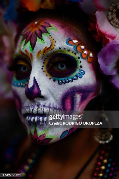 Woman dressed as a Catrin takes part in the Procession of Catrinas at the Reforma avenue in Mexico City, on October 22, 2023.