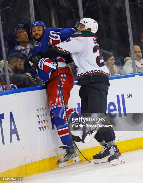 Matt Dumba of the Arizona Coyotes checks Vincent Trocheck of the New York Rangers into the boards during the second period at Madison Square Garden...