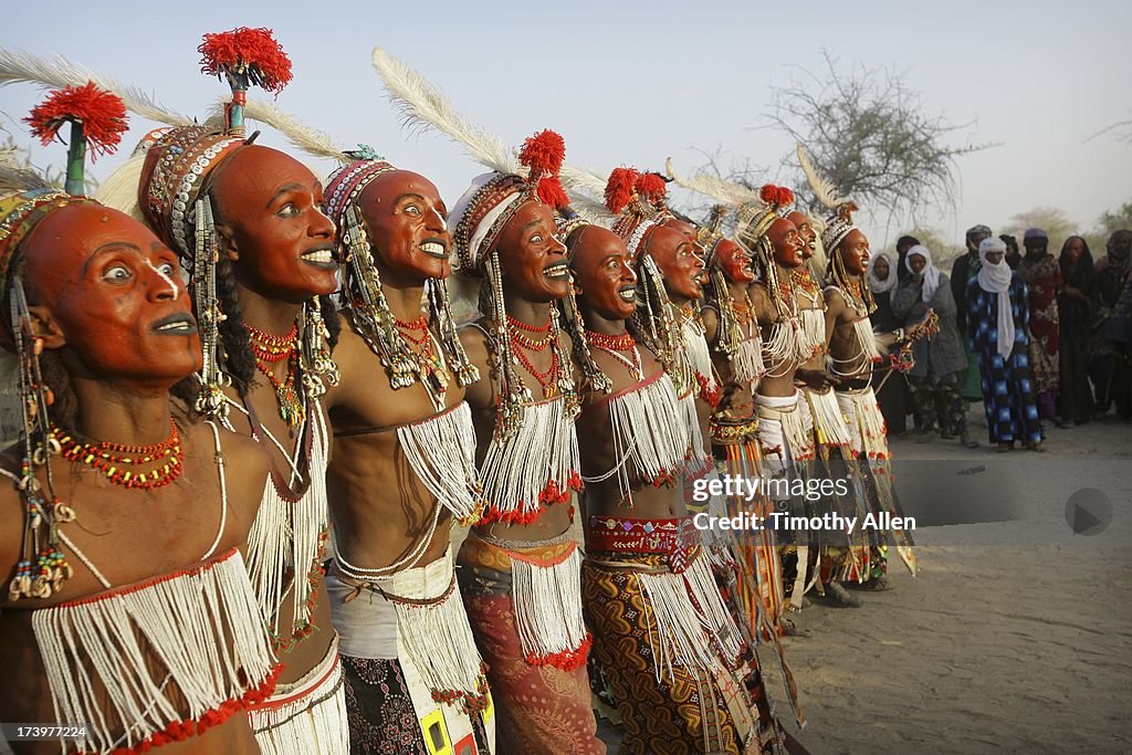 A line of men with red Ochre face paint dancing