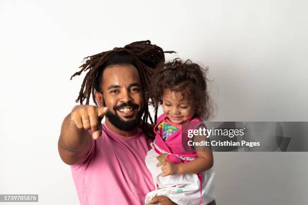 latin father with dreadlocks carrying his daughter happy on white background - nuevo leon state stock pictures, royalty-free photos & images