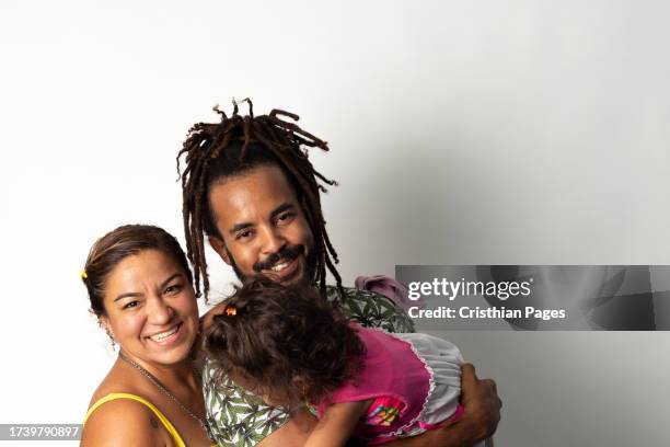 beautiful portrait of multiethnic happy family isolated on white background. carribean dad and mexican mom hugging daughther - nuevo leon state stock pictures, royalty-free photos & images