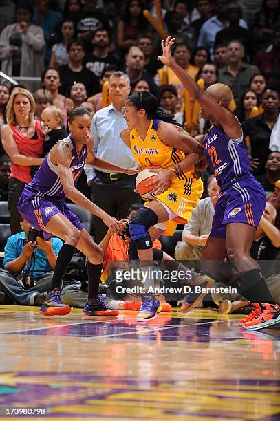 Candace Parker of the Los Angeles Sparks handles the basketball while being guarded by Dewanna Bonner and Charde Houston of the Phoenix Mercury at...